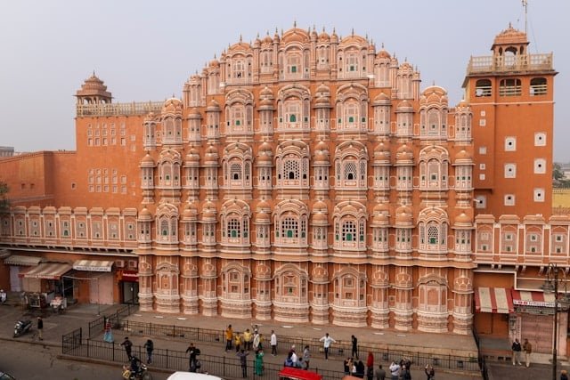a large building with many windows with Hawa Mahal in the background